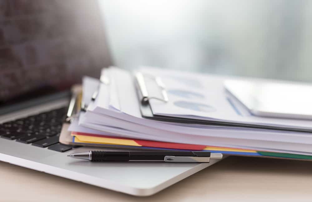 Stacked documents on a table.