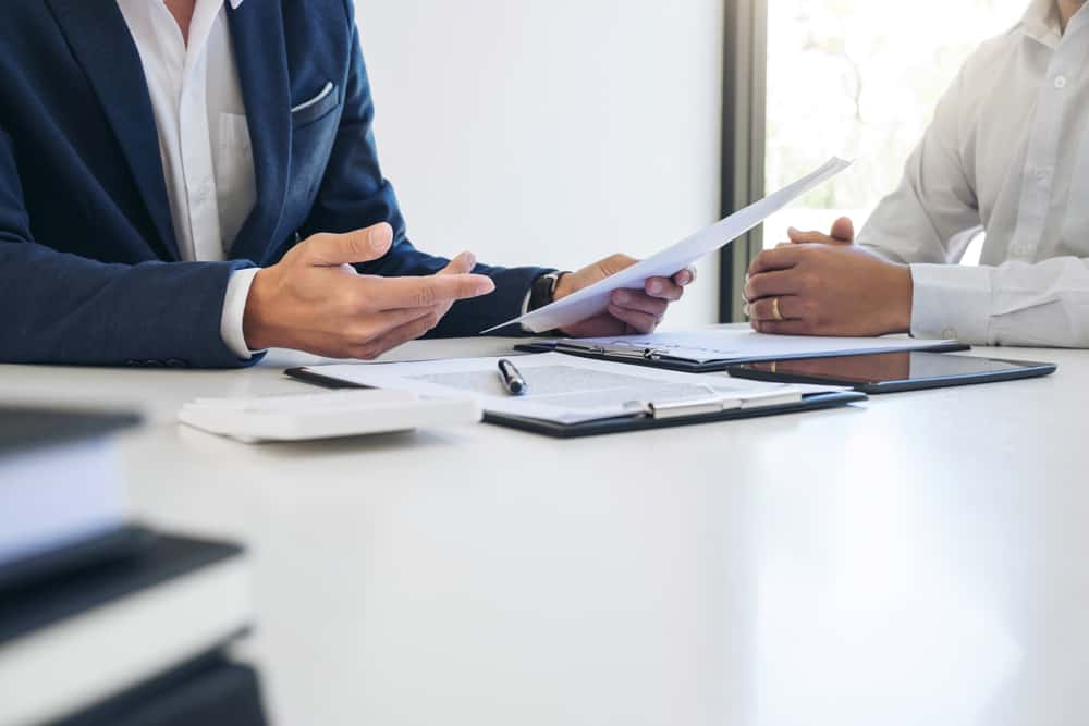 Businessmen handling paperwork during a meeting.